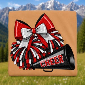 May include: A tan fabric square featuring a graphic print of a large red and white glittery hair bow layered over a cluster of red, white, and black pom-poms, accompanied by a black megaphone with the word CHEER printed in red block letters.