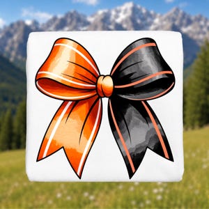 May include: A white square object featuring a large, centered graphic of a bow. The bow is split into two distinct halves, with the left side in vibrant orange and the right side in black, both accented by thin, light-colored stripes along the edges.