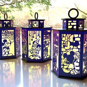 May include: Three hexagonal lanterns with Mickey Mouse and Minnie Mouse designs. The lanterns are dark blue with cut-out images and the words "Mickey Mouse". Each lantern has a black top with a circular handle.