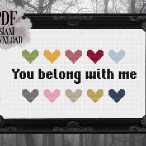 May include: Cross-stitch design in a black ornate frame. The design features the phrase "You belong with me" in black text, with colorful hearts above and below the text. The words "PDF Instant Download" are in the upper left corner.