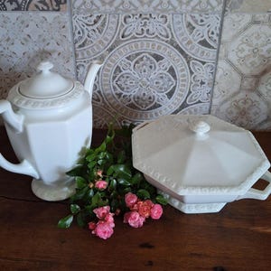 Puede incluir: Tetera y fuente de servir de porcelana blanca con un arreglo floral de rosas rosas.