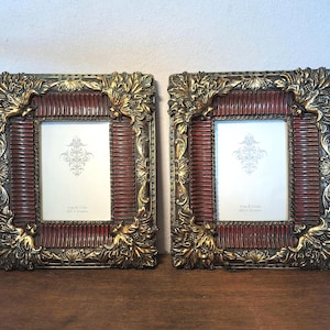 Puede incluir: Dos marcos de fotos ornamentados con una combinación de colores rojo y dorado. Los marcos tienen forma rectangular con un borde decorativo con motivos florales y de hojas. Cada marco tiene un inserto blanco con un diseño decorativo y el texto "4 in x 5 in" y "10 x 13 cm".