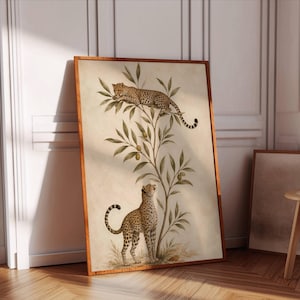 May include: A framed vertical wall art print featuring a beige background with a central olive tree. One cheetah is perched on the upper branches, while a second cheetah stands at the base of the tree looking upward. The artwork has a wooden frame.