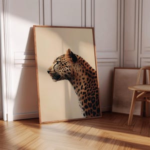 Puede incluir: Un primer plano de la cabeza y los hombros de un leopardo, mirando hacia un lado. El leopardo es marrón y negro con manchas. El fondo es de color beige claro.