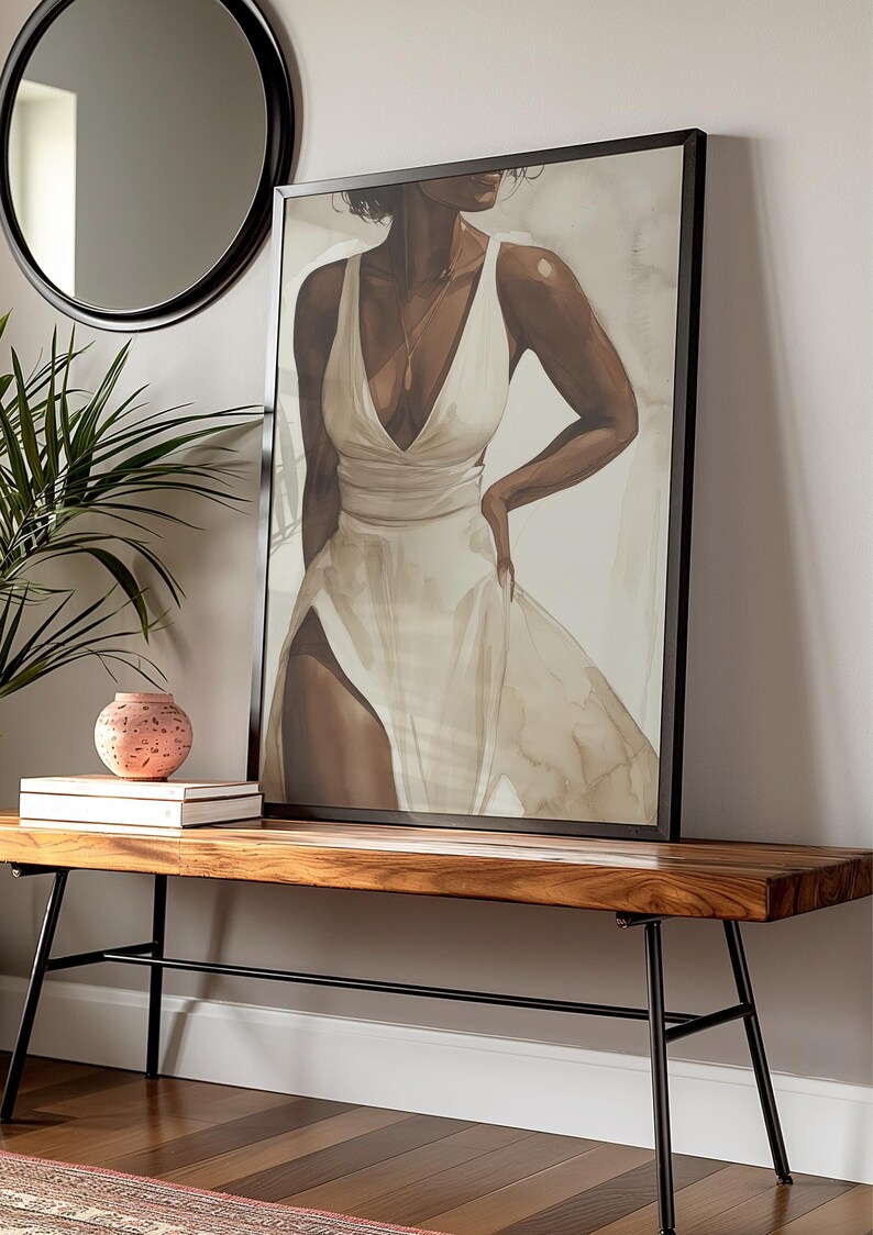 May include: A framed canvas print of a woman wearing a white dress. The woman is standing with her hand on her hip and looking to the side. The background is a light beige colour.