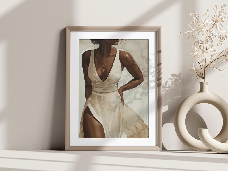 May include: A framed print of a watercolour painting depicting a woman in a white dress with a gold necklace. The woman is standing with her hand on her hip and looking to the side. The background is a soft, muted beige.