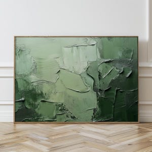 Puede incluir: Pintura abstracta con pinceladas gruesas en tonos verdes. La pintura está enmarcada en un marco de madera simple.
