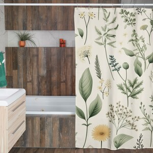 Puede incluir: Una cortina de ducha blanca con un patr&oacute;n floral verde y amarillo. El patr&oacute;n presenta varios tipos de flores y hojas.