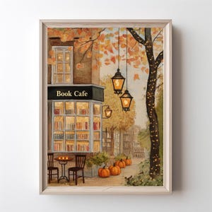 May include: A watercolour painting depicting a book cafe in autumn. The sign above the cafe reads "Book Cafe". The scene includes fall foliage, pumpkins, and lanterns hanging from a tree, creating a warm and inviting atmosphere.