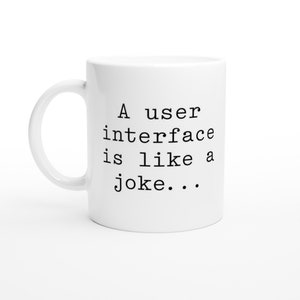 May include: White ceramic mug with black text that reads "A user interface is like a joke..."