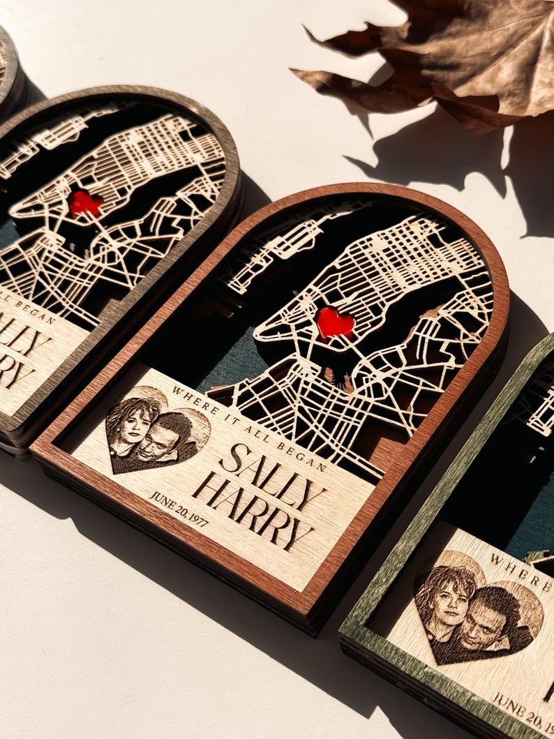 May include: Wooden map art featuring a laser-cut city map with a red heart marking a location. The art includes a photo and the text "WHERE IT ALL BEGAN", "SALLY HARRY", and "JUNE 20, 1977".