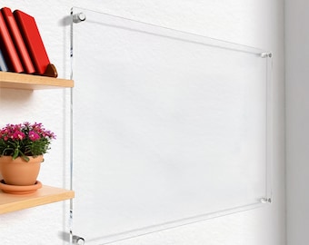 May include: A clear acrylic wall mounted display shelf with rounded edges and silver mounting hardware. The shelf is mounted on a white wall.