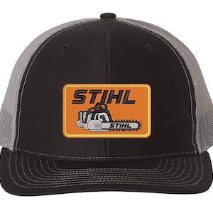 May include: Black and gray trucker hat with a black and orange patch featuring a chainsaw and the text "STIHL".