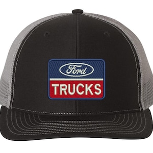May include: A black and gray trucker hat with a red, white, and blue embroidered patch that says "Ford Trucks".