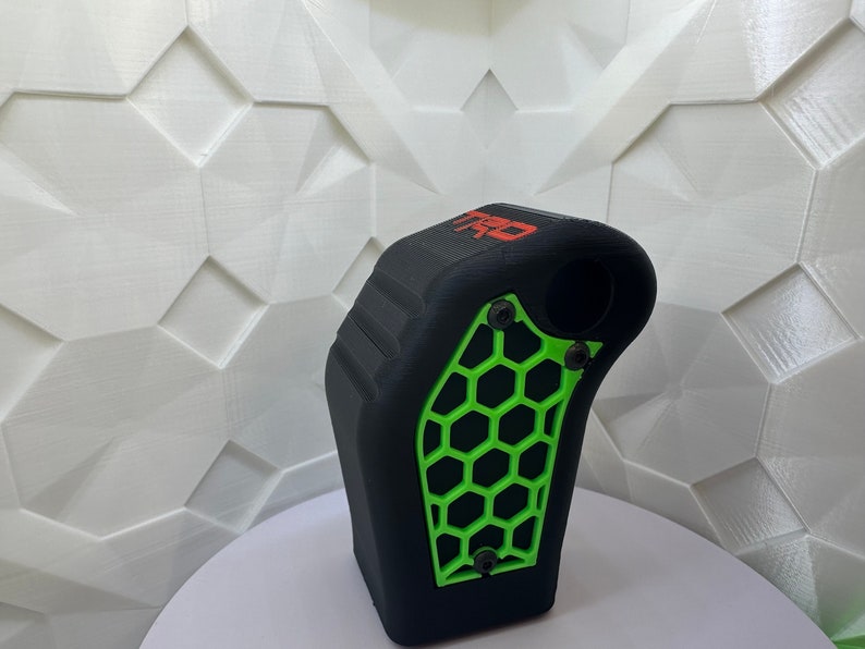 May include: Black and green 3D printed gear shift knob with a honeycomb pattern and the word "TRD" printed in red.