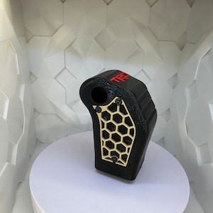 May include: Black 3D printed gear shift knob with a gold honeycomb design and the word "TRD" in red lettering.