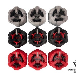 Puede incluir: Conjunto de diez marcadores de bola de golf, con un diseño negro y rojo con un logotipo blanco. Los marcadores están dispuestos en tres filas, con tres marcadores en cada fila. Los marcadores están hechos de plástico y tienen una forma circular.