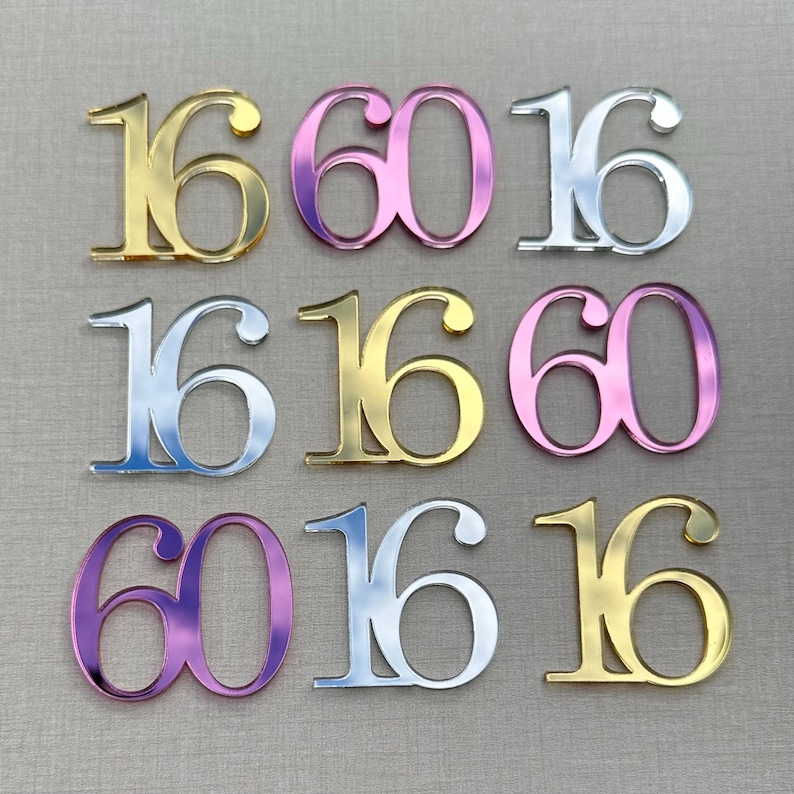 May include: Nine decorative number cutouts in gold, pink, and silver. The numbers are arranged in a grid pattern, with the numbers 16 and 60 repeated. The cutouts have a reflective, metallic finish.
