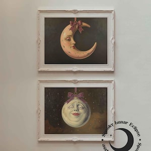 May include: Two framed paintings of celestial bodies. The top painting shows a crescent moon with a face, decorated with a purple bow. The bottom painting depicts a smiling full moon with a purple bow, against a starry backdrop.