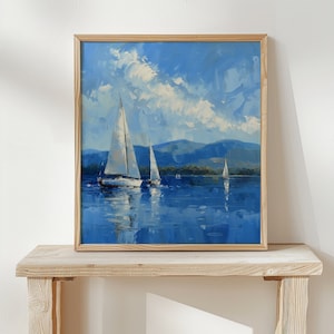 May include: A framed painting depicting three sailboats on a lake, with a blue sky and white clouds. The sailboats are white and the water is blue. The painting is framed in a light wood frame.