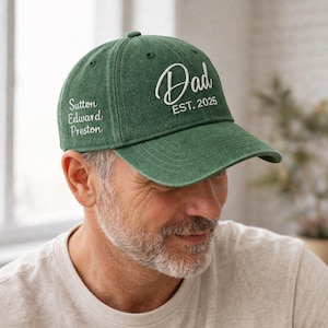 May include: A green baseball cap with the word "Dad" in white script and "EST. 2026" embroidered on the front. The cap also features the embroidered name "Sutton Edward Preston" on the side.