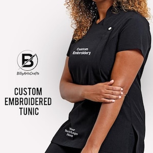 May include: Black tunic with a white embroidered logo that says "Custom Embroidery" and a smaller logo that says "BillyArtsCrafts". The tunic has a white button on the collar and a side slit on the right side.