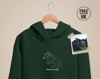 May include: A dark green hoodie with a white outline of a horse and rider. The text "Morgan and poppy" is printed below the image. A photo of a horse and rider is included in the corner of the image with the text "Your Photo" below it.