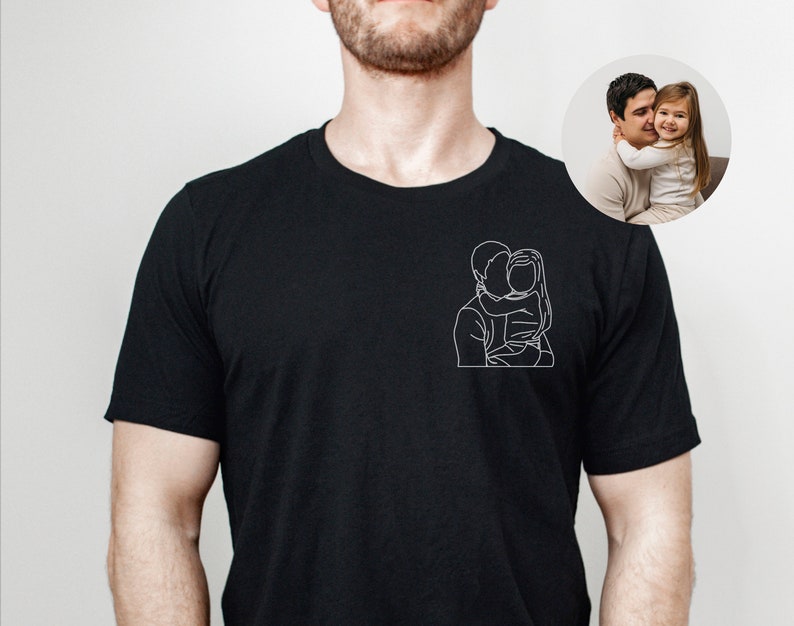 May include: Black t-shirt with a white line drawing of a father and daughter hugging.