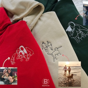 May include: Three hooded sweatshirts in red, beige, and green with white embroidered images of people and a dog. Each sweatshirt has a photo of a different family on the sleeve.