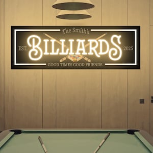 May include: A pool table with a green felt surface, cue sticks, and a rack of billiard balls. Above the table is a sign that reads "Billiards" in a neon-style font, with the text "Good Times Good Friends".