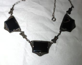 Collar antiguo Art Déco de cristal negro con intrincados detalles florales en metal.