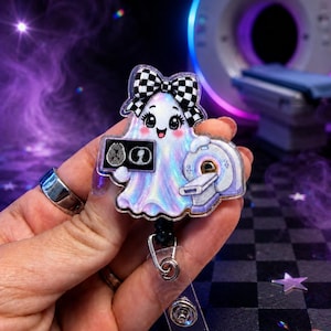 May include: An acrylic badge reel featuring a cute, iridescent ghost character with a black and white checkered bow. The ghost holds a small medical scan image and stands next to a miniature CT scanner machine, all rendered in a glossy finish.