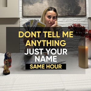 May include: A set of tarot cards held in a fan shape, with additional cards spread on a white tablecloth. A small gold cat figurine and a colorful nesting doll sit on the left, while a tall beige candle stands on the right. Text reads: DONT TELL ME ANYTHING JUST YOUR NAME SAME HOUR.