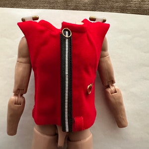 Op de afbeelding: Een rood vest zonder mouwen met een zwarte rits en gouden accenten. Het vest is gemaakt van een zacht, fluweelachtig materiaal.