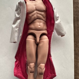 May include: A white long-sleeved coat with a pink lining. The coat is open and the lining is visible. The coat is made of a soft, silky fabric.