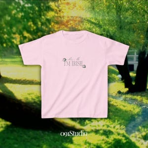 May include: Pink t-shirt with the text "Kiss Me I'm Irish" and a shamrock design.