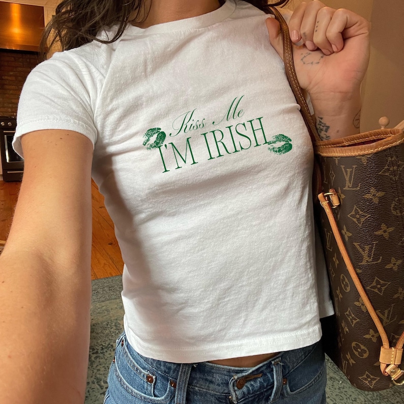 May include: White t-shirt with green shamrock lips and the text "Kiss Me I'm Irish".