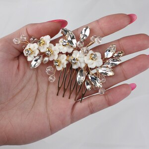 a woman's hand holding a hair comb with flowers on it