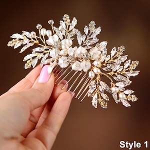 A hand holding a decorative hair accessory with a floral design and sparkling elements.