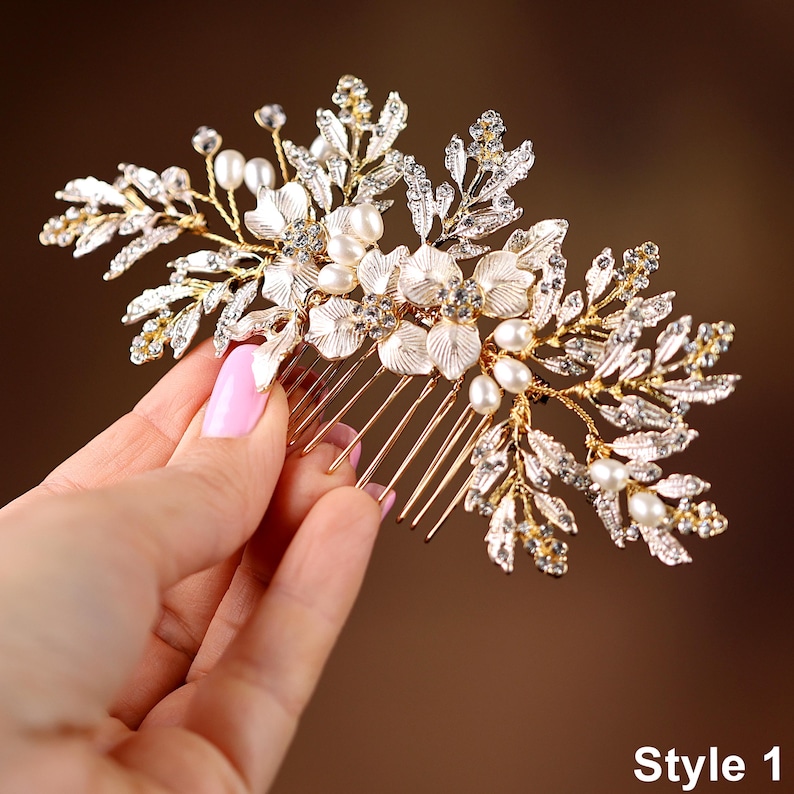 A hand holding a decorative hair accessory with a floral design and sparkling elements.