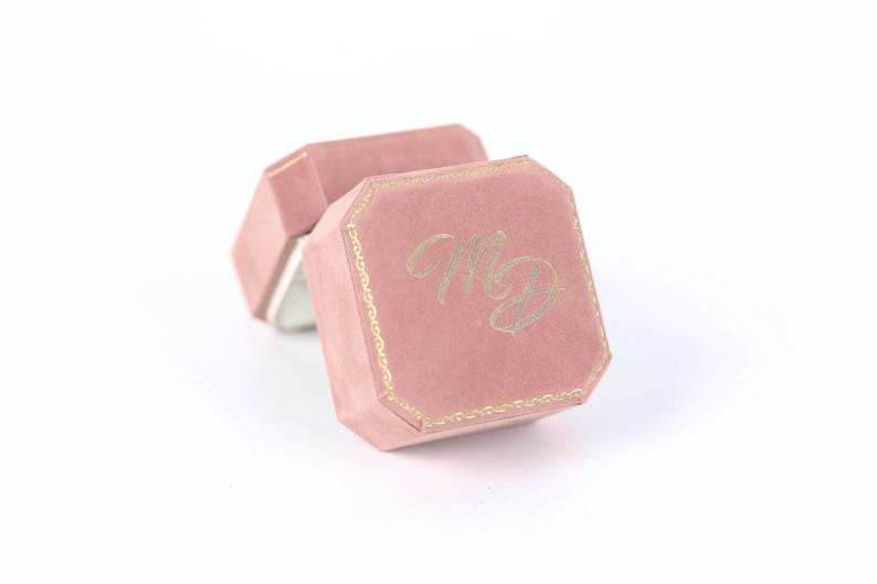 A pink velvet box with the initials "MD" embossed on it.