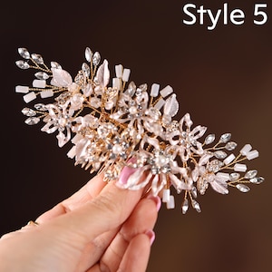 A hand holding a decorative hair accessory with intricate floral and crystal embellishments.
