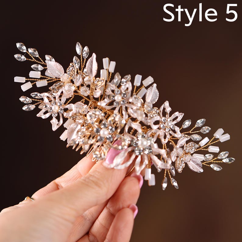 A hand holding a decorative hair accessory with intricate floral and crystal embellishments.
