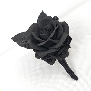 a single black rose on a white cloth