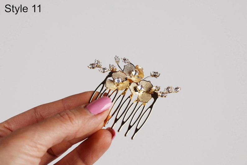 A hand holding a decorative hair accessory with a floral design.