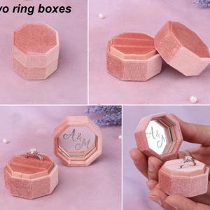 a pink ring box with two rings inside of it