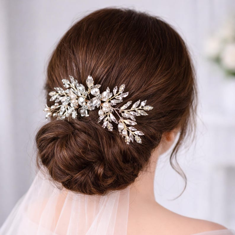 a woman's back view with her hair styled in a bun, adorned with a decorative hair accessory featuring small, sparkling stones.