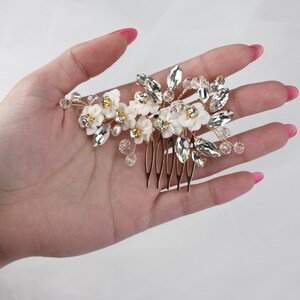 a woman's hand holding a hair comb with flowers on it