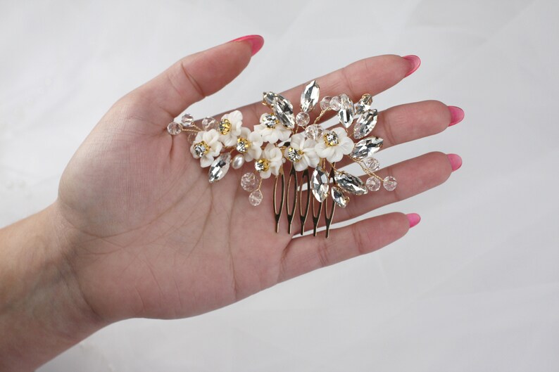 a woman's hand holding a hair comb with flowers on it