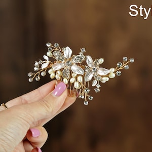 A hand holding a decorative hair accessory with flowers and pearls.